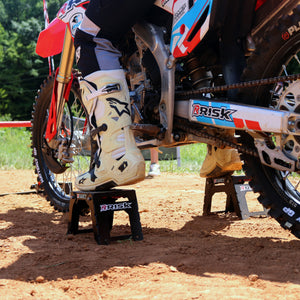Close up of a pair of Adjustable Motocross Starting Blocks with just the motocross riders boots in view gently sitting on top