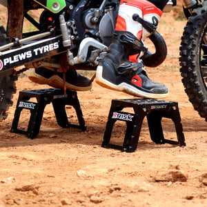 Close up of a pair of Adjustable Motocross Starting Blocks with just the motocross riders boots in view gently sitting on top
