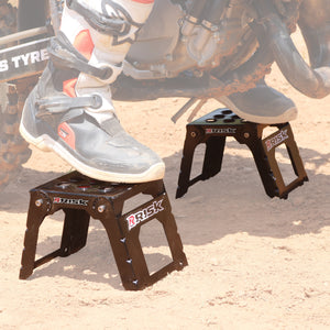 Adjustable Motocross Starting Blocks Risk Racing Lifestyle with racers boots and ground faded out to highlight the blocks
