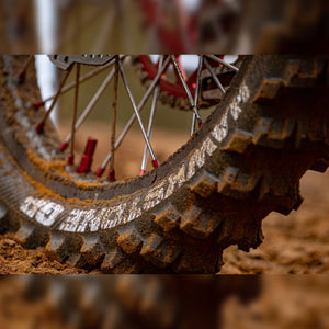 Super close up of a dirty motocross tire. Hawkstone GP writing upside down on the tire.